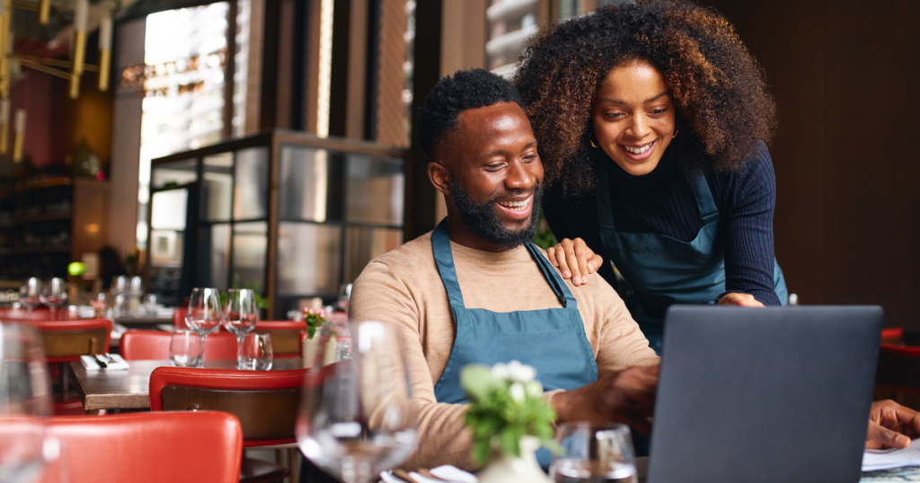 Smiling business owners reviewing financing options for bad credit business loans in California.