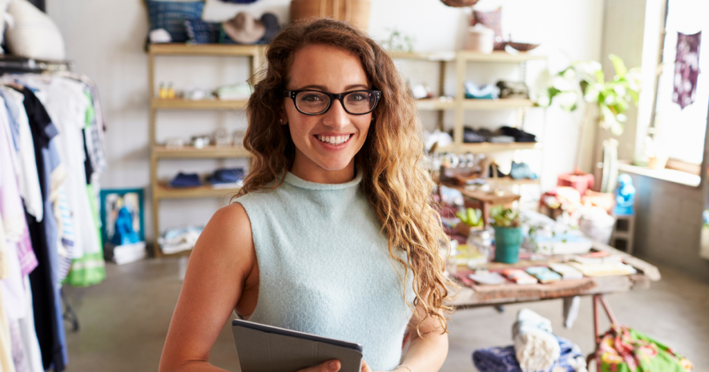 Smiling businesswoman in a retail store, showcasing flexible merchant cash advances for business growth.