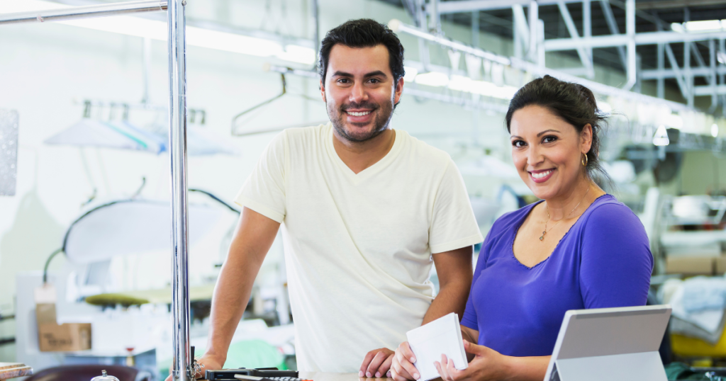 Business owners smiling in a service environment, showcasing teamwork and the importance of unsecured business lines of credit.