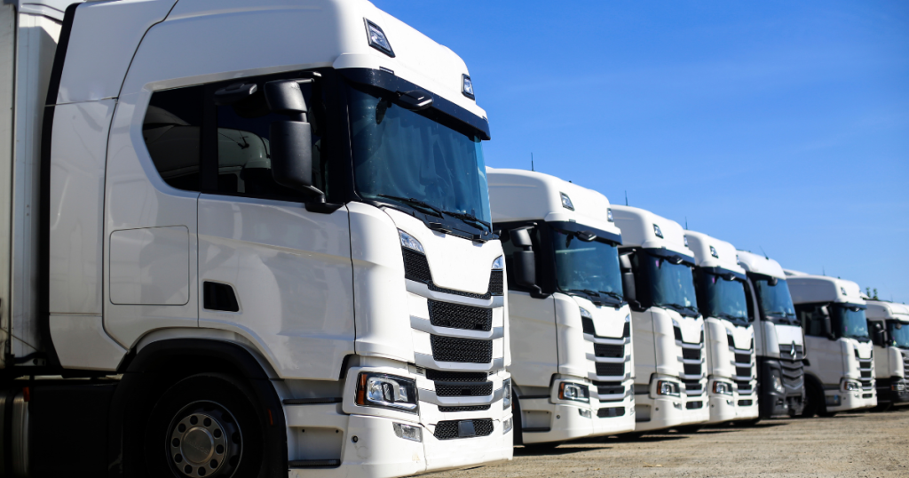 Heavy equipment financing solutions for trucking businesses, showcasing a line of white trucks ready for operation.