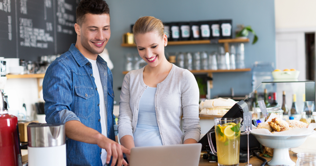 Two people discussing business strategies in a cafe, highlighting health goals and fitness trends for entrepreneurs.