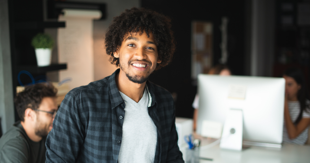 Smiling small business owner in an office, representing unsecured financing and support for SMB credit recovery.