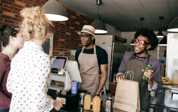 Business owners discussing strategic financial decisions at a cafe, emphasizing growth and customer engagement.