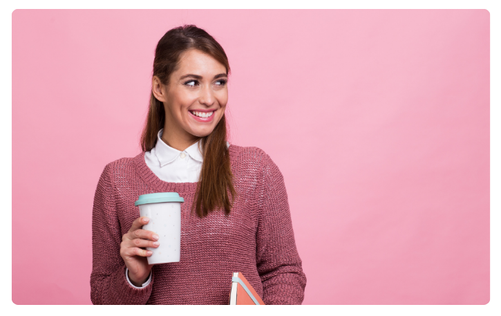 Smiling woman holding a coffee cup and notebook, representing small business empowerment and financing solutions.