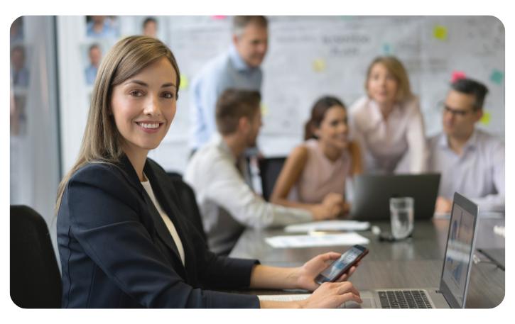 Business professional using a smartphone in a meeting, highlighting strategic credit card benefits for growth.