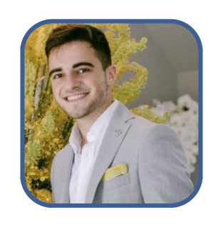 Smiling young man in a suit with a yellow pocket square, representing leadership qualities for successful CEOs.