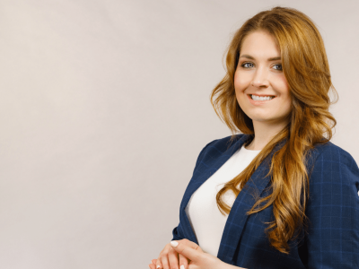 Professional woman smiling in a business suit, representing business credit card management and financial solutions.
