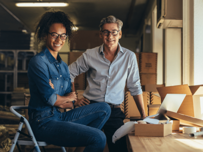 Business partners discussing merchant cash advance strategies in a warehouse, focusing on financial growth and funding solutions.
