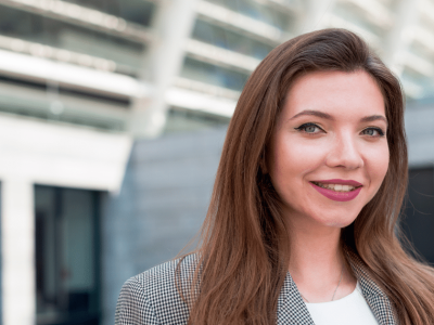 Professional woman smiling outdoors, representing customer retention strategies and business growth.