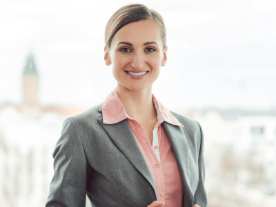 Professional woman smiling in a business suit, representing small business growth and New Year’s resolutions.
