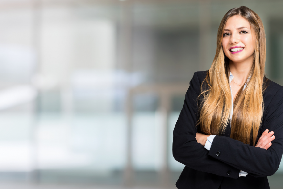 Professional woman in business attire smiling, representing small business loan options and lending trends.