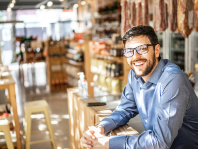 Smiling business owner in a retail store, showcasing flexible credit options for business growth and funding solutions.