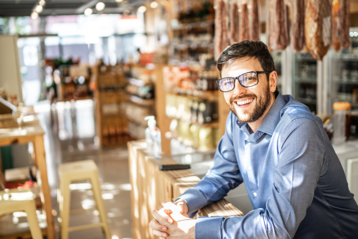 Smiling business owner in a retail store, showcasing flexible credit options for business growth and funding solutions.