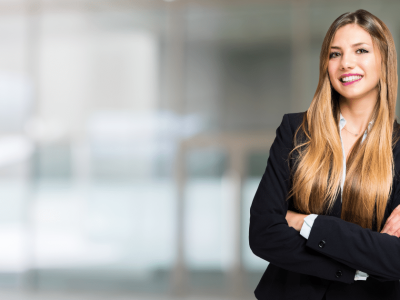 Professional woman in business attire smiling, representing small business loan options and lending trends.