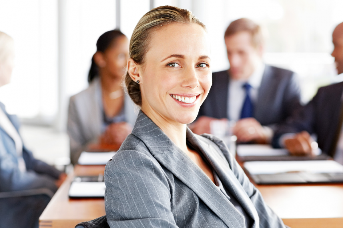 Smiling businesswoman with a laptop, representing financial success and smart business management strategies.