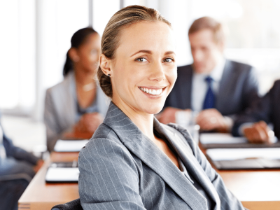 Professional woman smiling in a business meeting, representing effective marketing strategies and lead conversion.