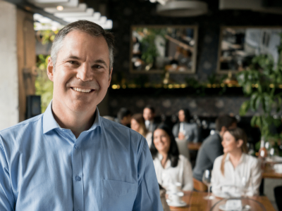 Smiling businessman in a restaurant, representing flexible business loan solutions for New York merchants.