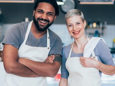 Smiling business owners in aprons representing small business growth and financing solutions for success.