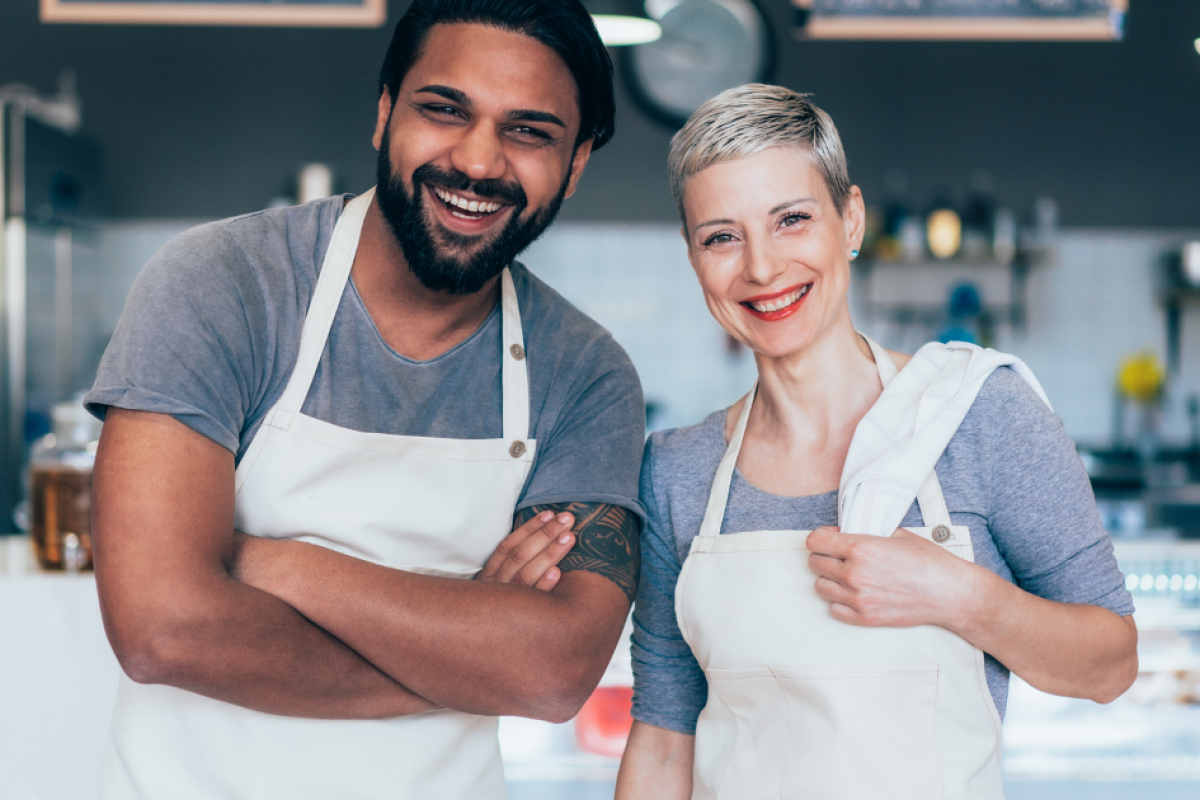 Smiling business owners in aprons representing small business growth and financing solutions for success.