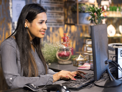 Businesswoman working on a computer, exploring bad credit loans for DME business growth and recession resilience.