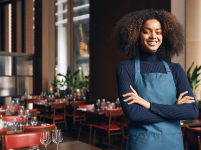 Smiling restaurant owner in an apron, showcasing confidence and readiness to boost business with unsecured bad credit loans.