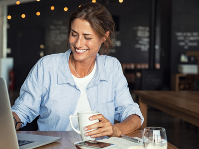 Business owner in a suit standing confidently in a modern cafe, representing growth through Merchant Advance Loans.