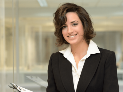 Professional woman in business attire smiling, representing strategic business loans and financial growth opportunities.