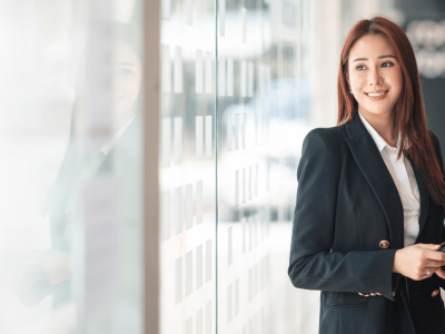 Business professional smiling while holding a tablet, representing success and planning for business growth.