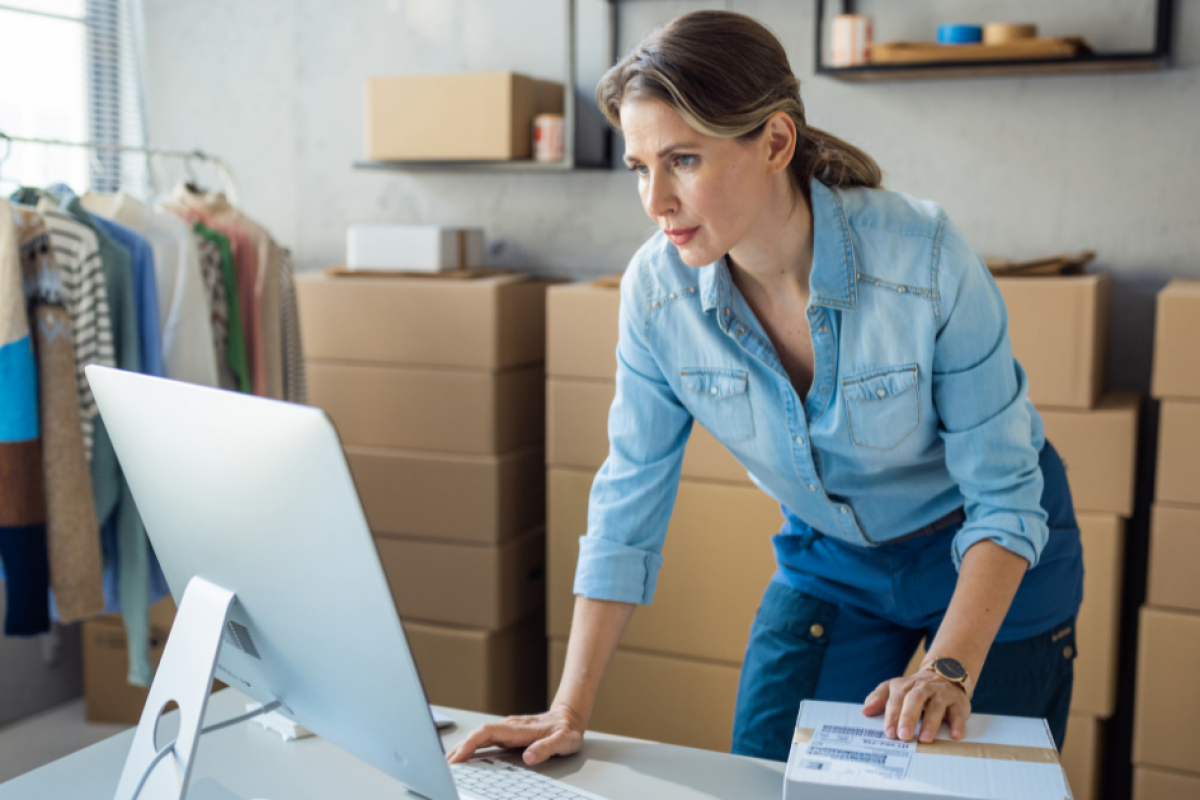 Woman managing business finances with a computer in a retail space, highlighting unsecured credit line benefits.