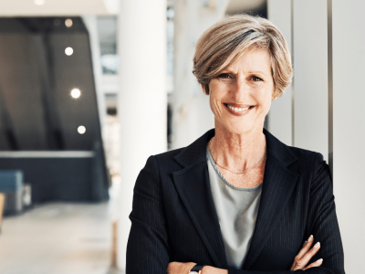 Smiling businesswoman in a professional setting, representing offline marketing strategies for small businesses.