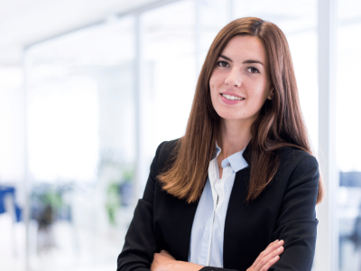 Businesswoman in a modern office, representing effective management for multiple locations and team collaboration.