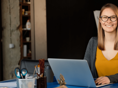 Smiling woman in an office setting, promoting small business growth through essential SEO tips and strategies.