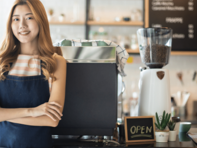 Smiling business owner in a cafe, showcasing growth potential with unsecured lines of credit for small businesses.
