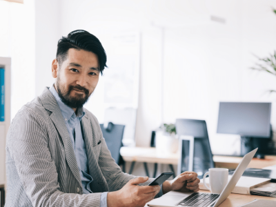 Business professional using a laptop and smartphone in a modern office, exploring unsecured small business line of credit options.