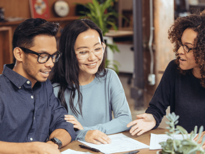 Diverse group discussing small business funding options with documents on the table in a collaborative workspace.