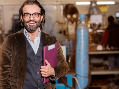 Smiling business owner in a workshop, showcasing successful franchising and business growth strategies.