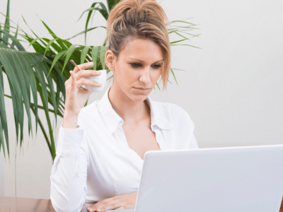 Businesswoman analyzing lease options on a laptop, highlighting operating vs. capital leases for financial decisions.