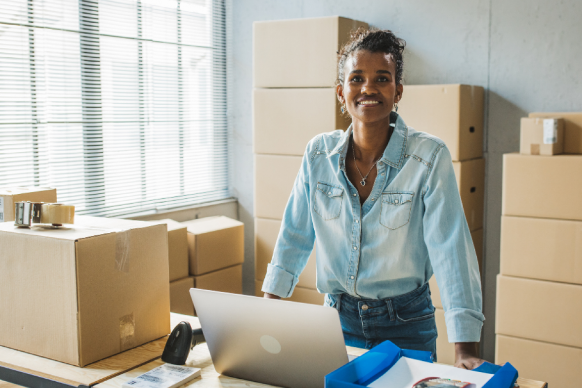 Smiling barista in a coffee shop, showcasing business growth and credit card receivable financing opportunities.