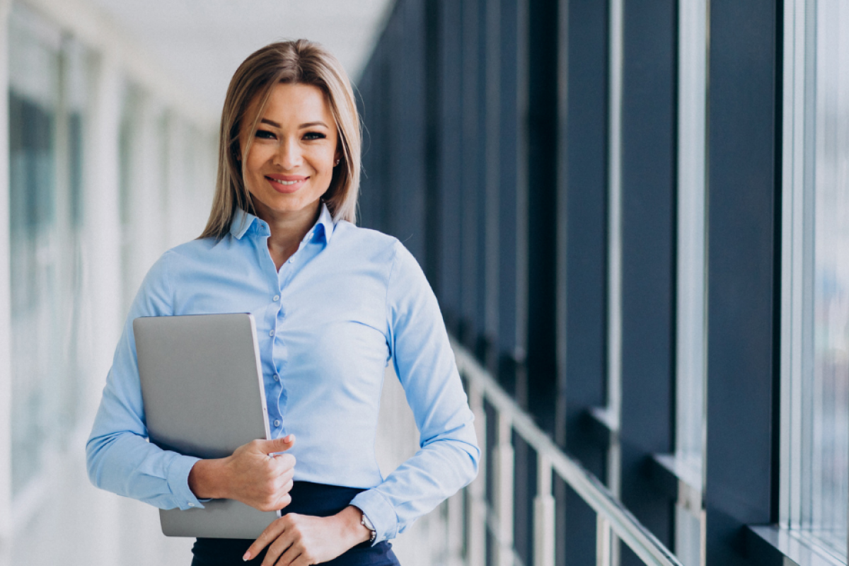 Professional woman holding a laptop, representing mobile marketing strategies for business success and local SEO optimization.