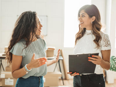 Two businesswomen discussing innovative cash advance solutions in a modern office setting.