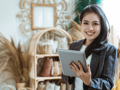 Smiling businesswoman holding a tablet, representing merchant cash advances and business growth solutions.