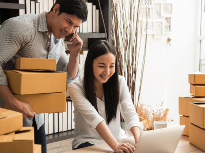 Small business owners discussing financing options with boxes, representing easy credit lines and funding solutions for bad credit.