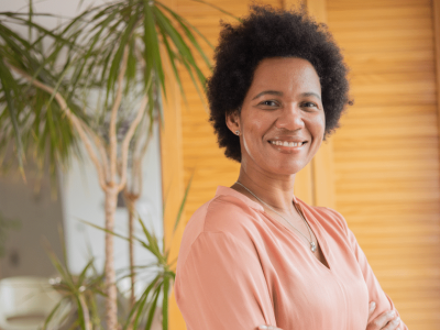Smiling woman in a restaurant setting, emphasizing customer service and employee performance improvement strategies.