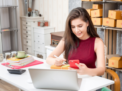 Business owner managing finances and planning debt repayment strategies at a desk with a laptop and office supplies.