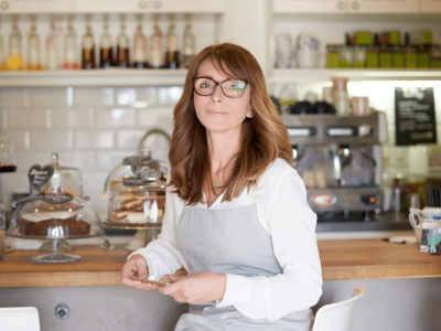 Restaurant owner in a cozy cafe setting, promoting holiday trends and funding solutions for business success.