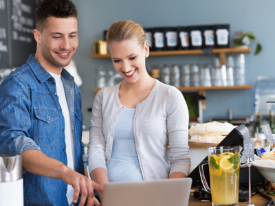Two people discussing business strategies in a cafe, highlighting health goals and fitness trends for entrepreneurs.