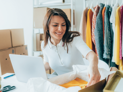 Woman managing inventory and finances for her small business, utilizing receivables factoring for cash flow.