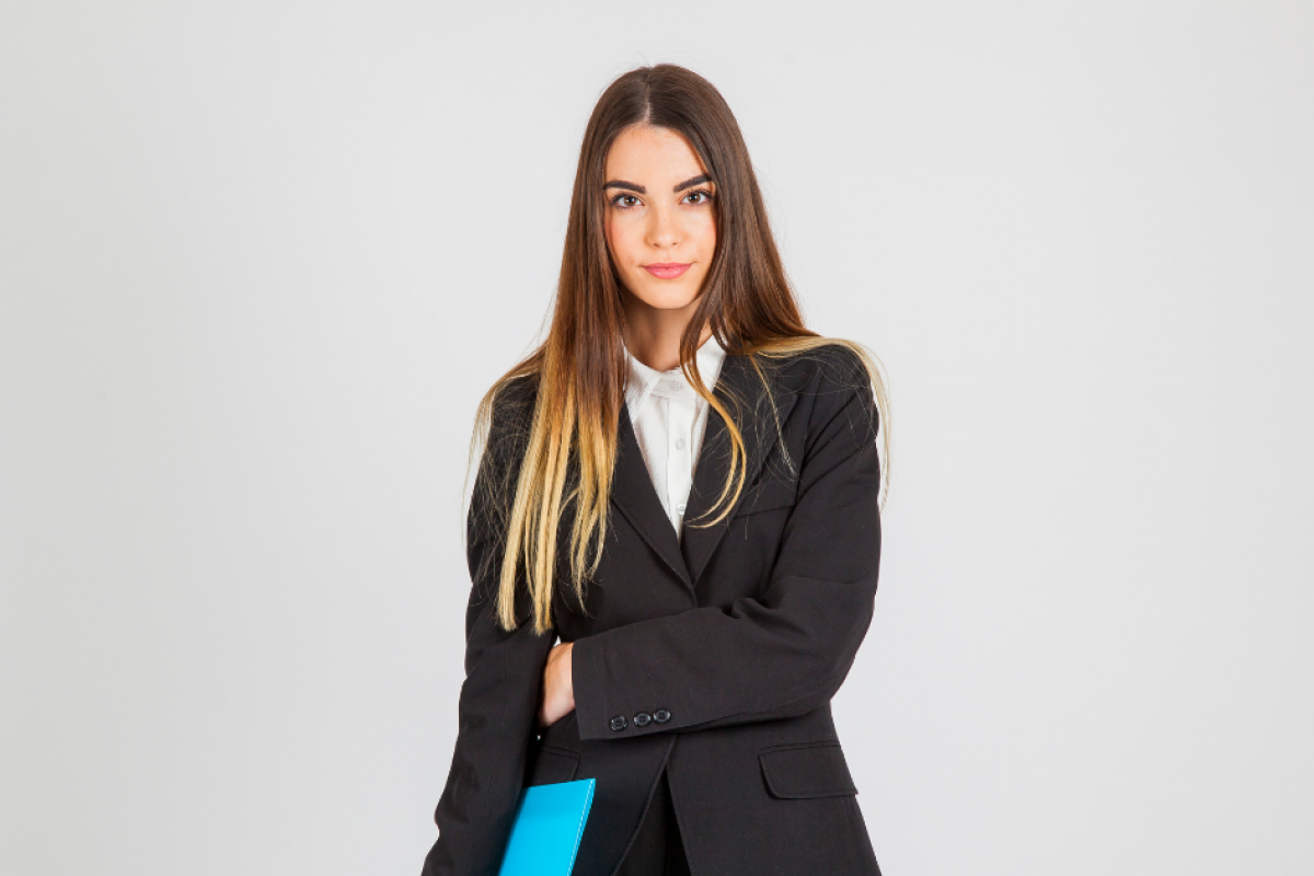 Professional woman in a suit holding a blue folder, representing customer engagement strategies in business.