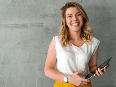 Smiling woman holding a tablet, representing small business loans and financial empowerment for entrepreneurs.