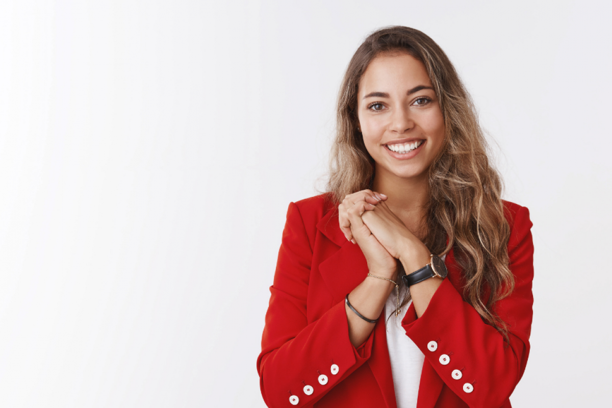 Smiling woman in a red blazer representing effective customer engagement strategies for small businesses.